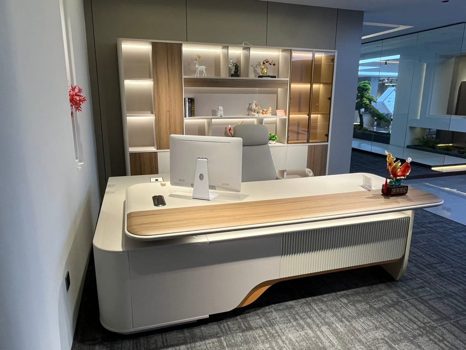 An executive desk and lit gallery wall framed as it appears on a video call